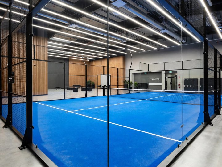 Court padel indoor dengan dinding kaca dan garis lapangan