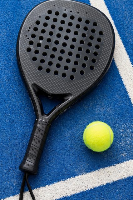Raket padel dan bola di atas court